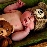 Dexter joined the competition — help win amazing prizes! baby, infant, knitted_hat, bear_hat, plush_toy, stuffed_animal, green_blanket, soft_texture, cute, child, newborn, sleepwear, relaxing, indoors, portrait, closeup, hand, face, expression, resting