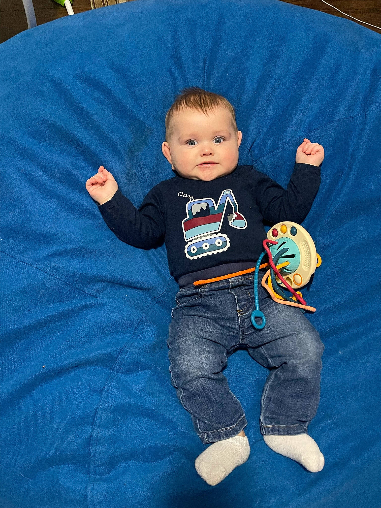 Henry is registered to the contest to win money with this photo: arm, baby, baby_products, baby_toddler_clothing, child, comfort, electric_blue, finger, flooring, fun, happy, linens, logo, person, play, sitting, sleeve, sportswear, t_shirt, toddler
