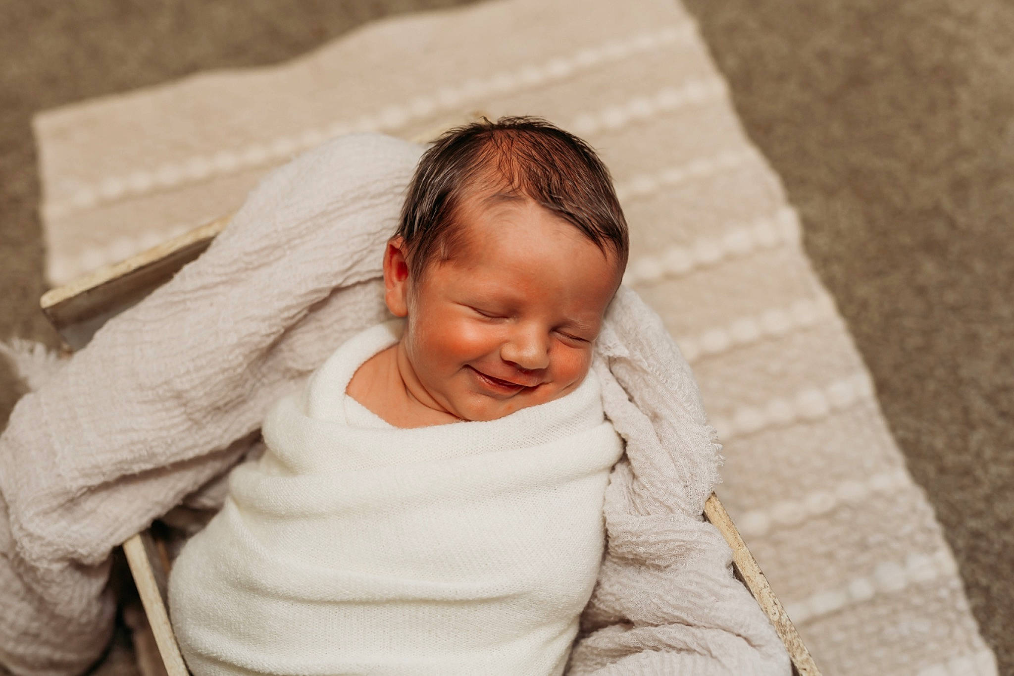 Lawson is registered to the contest to win money with this photo: baby, black_hair, child, chin, comfort, eye, face, floor, flooring, hand, happy, head, linens, monochrome, neck, person, sitting, skin, sleeve, smile