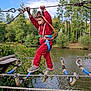 Emilio participe au concours pour gagner de l'argent avec cette photo : activity, adventure, casual_clothing, child, climbing, daytime, exercise, fun, greenery, harness, nature, outdoor, playground, pond, rope, rope_course, safety_gear, sky, trees, young_child