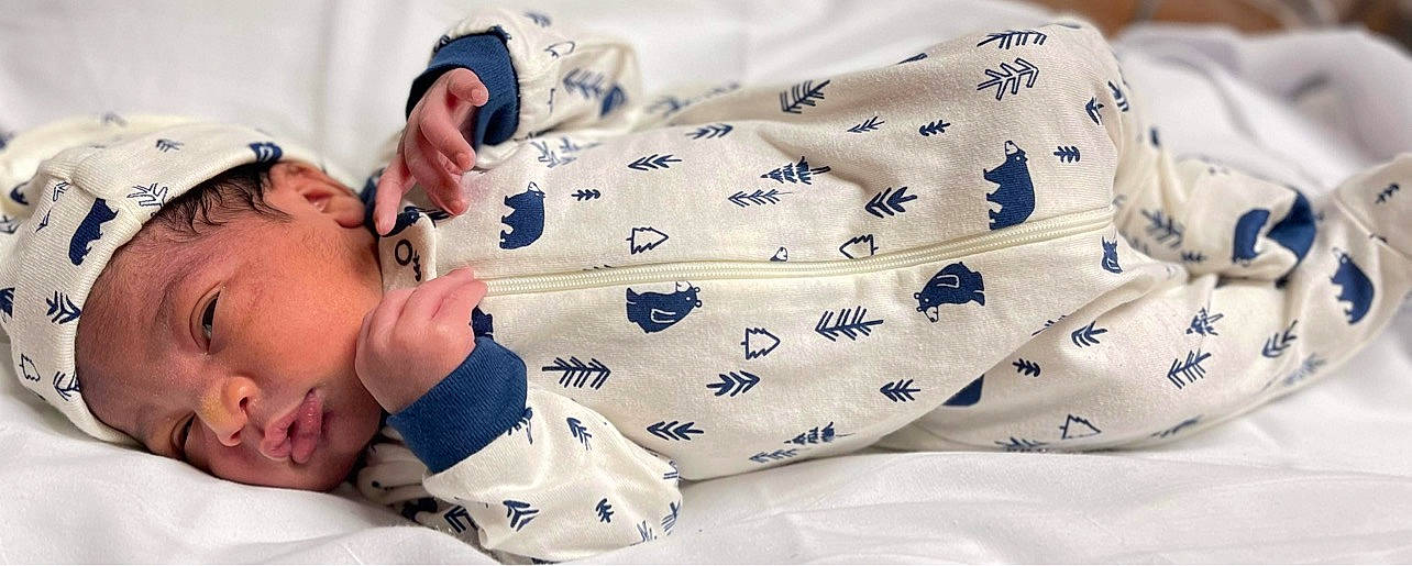 Kylen is registered to the contest to win money with this photo: baby, baby_products, baby_sleeping, baby_toddler_clothing, bedding, child, comfort, elbow, finger, gesture, happy, headwear, linens, nail, pattern, person, sitting, skin, sleeve, t_shirt