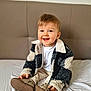 Matteo participe au concours pour gagner de l'argent avec cette photo : bed, child, clothing, cozy, cute, face, fashion, footwear, hair, happy, indoor, jacket, person, portrait, shoes, sitting, smiling, toddler, white_shirt, young