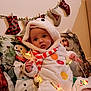 Ippo is registered to the contest to win money with this photo: baby, child, snowman_costume, christmas_lights, holiday, festive, stockings, pillow, couch, indoors, cute, toddler, smiling, holiday_decor, red_and_white, plush, face, person, christmas, cozy