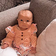 Connie joined the competition — help win amazing prizes! baby, infant, child, couch, pillow, blanket, indoors, clothing, pink, floral, portrait, sitting, cute, face, head, person, soft, cozy, home, young