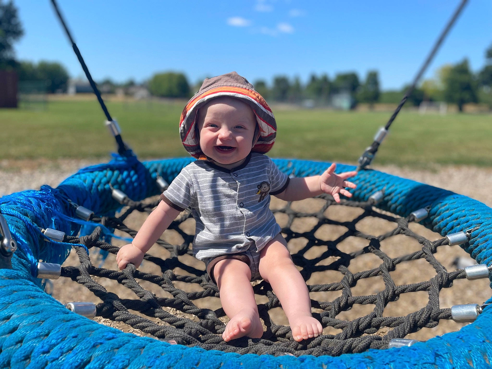 Waylen is registered to the contest to win money with this photo: automotive_tire, blue, cloud, electric_blue, fun, grass, happy, hat, headwear, joy, landscape, leisure, outdoor_play_equipment, people_in_nature, person, recreation, sky, smile, sun_hat, tire