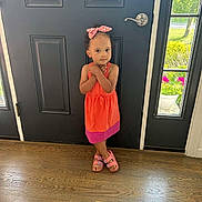 Ivory is registered to the contest to win money with this photo: child, girl, dress, standing, door, indoor, floor, wood_floor, sandals, hair_bow, curly_hair, portrait, person, cute, young_child, casual_clothing, natural_light, window, plant, shy