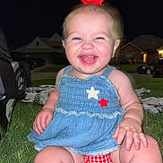 Oaklynn is registered to the contest to win money with this photo: baby, child, smiling, grass, night, dress, red_bow, outdoor, happy, cute, tooth, face, person, sitting, laughter, cheerful, skin, legs, head, photography