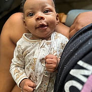 Icelynn is registered to the contest to win money with this photo: baby, infant, child, smiling, face, hand, clothing, pajamas, pattern, animal_print, person, lap, skin, cute, closeup, expression, indoors, comfort, holding, human