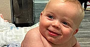 Wilson joined the competition — help win amazing prizes! baby, blanket, blue_eyes, cheeks, child, cute, expression, floor, flooring, hand, happy, home, indoor, infant, naked_torso, person, skin, smiling, toy, whale_pattern