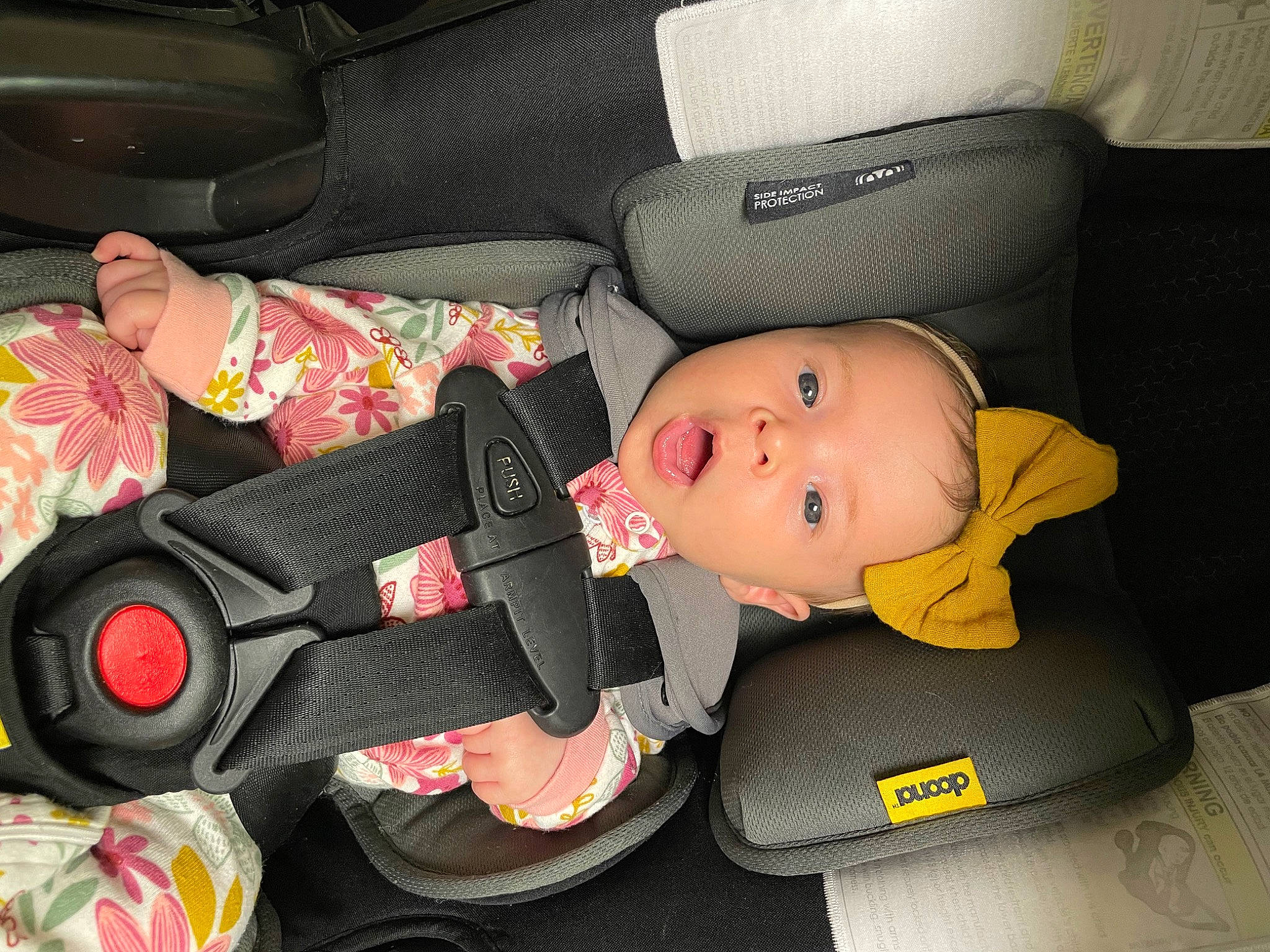 Lily is registered to the contest to win money with this photo: auto_part, automotive_wheel_system, baby, baby_carriage, baby_products, baby_toddler_clothing, black, car_seat, car_seat_cover, carmine, child, comfort, family_car, hat, motor_vehicle, person, product, seat_belt, smile, surprise