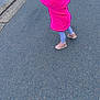 child, pink_coat, leggings, shoes, road, pavement, curb, outdoor, street, motion, walking, side_view, childhood, urban, casual_clothing, young_child, person, hairstyle, playful, daytime