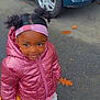 child, girl, pink_jacket, headband, yellow_ring, outdoor, pavement, leaves, car, blue_car, autumn, smiling, cute, boots, toddler, playful, standing, person, clothing, toy