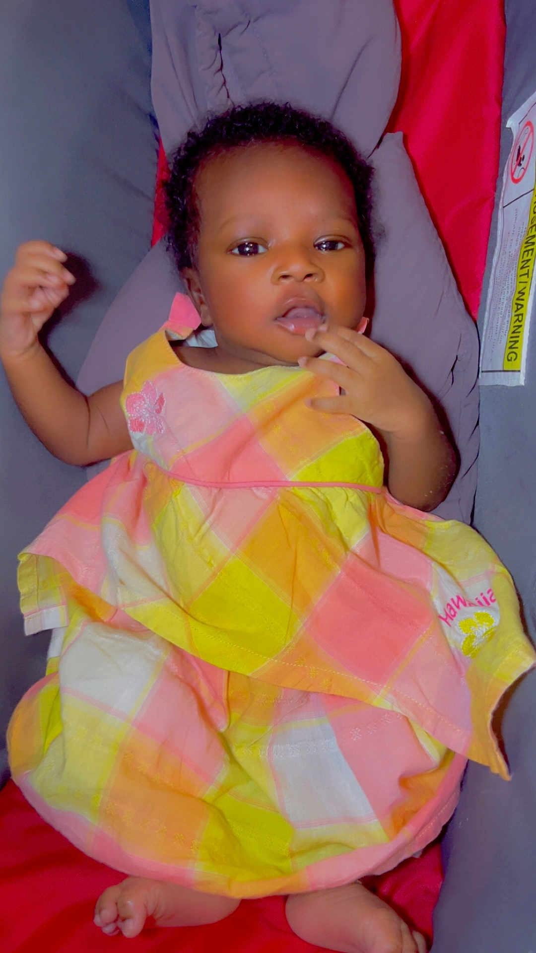 Fatimetou participe au concours pour gagner de l'argent avec cette photo : baby, infant, child, dress, plaid, yellow, pink, cushion, seat, foot, hand, face, person, indoor, cute, curious, skin, clothing, small_toes, relaxed