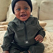 Drayson joined the competition — help win amazing prizes! baby, infant, smiling, beanie, hat, jacket, jumpsuit, socks, blanket, couch, sofa, living_room, portrait, cute, happy, big_eyes, dark_skin, hand, feet, plush