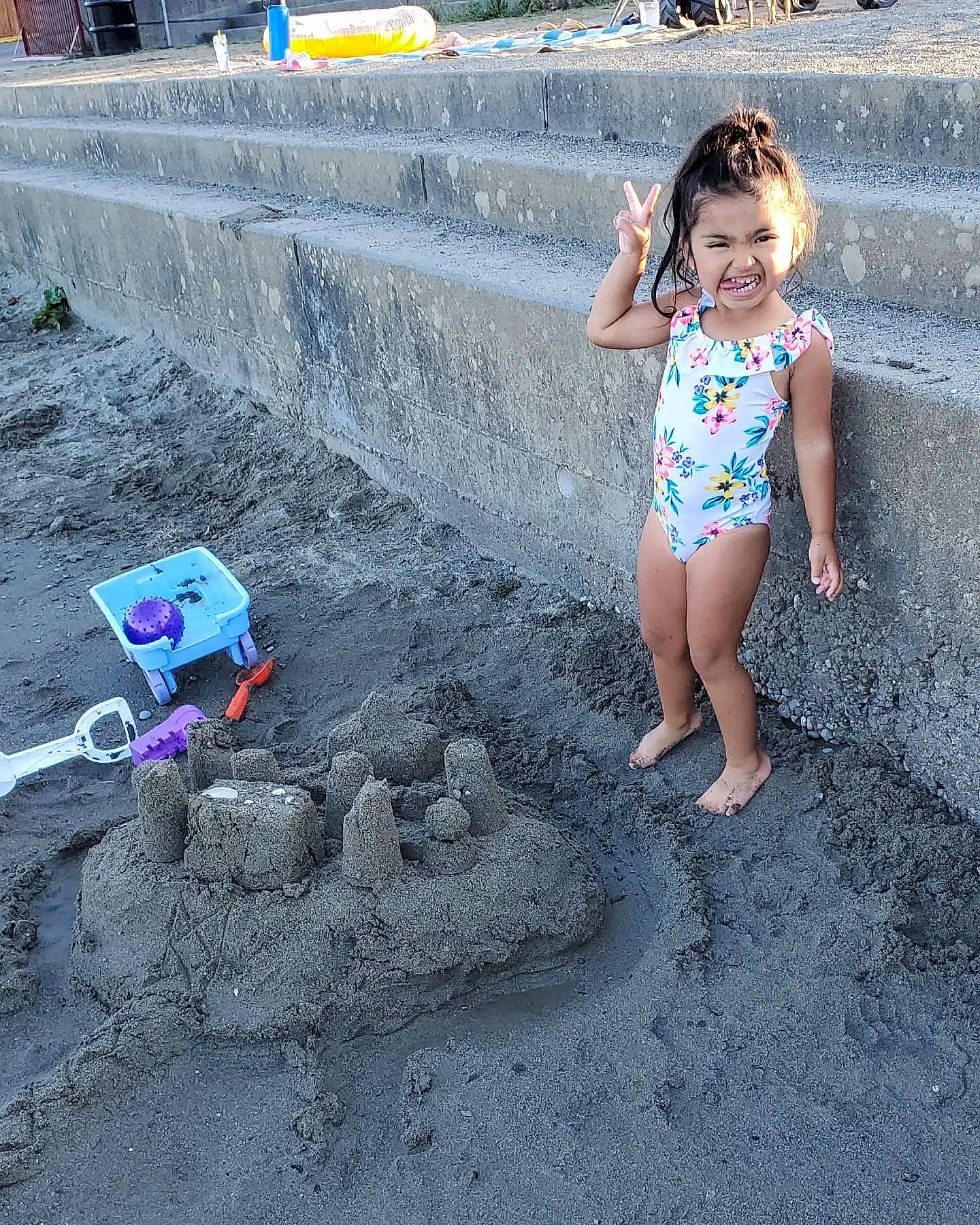 Saige is registered to the contest to win money with this photo: anger, asphalt, barefoot, bench, child, city, concrete, foot, fun, happy, human_leg, leisure, person, play, recreation, road_surface, sand, smile, soil, swimwear