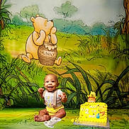 Daquon Jr joined the competition — help win amazing prizes! baby, background, birthday_cake, cake, cartoon, celebration, child, clothing, decor, floor, grass, happy, milestone, onesie, party, sitting, smile, toy, winnie_the_pooh, yellow