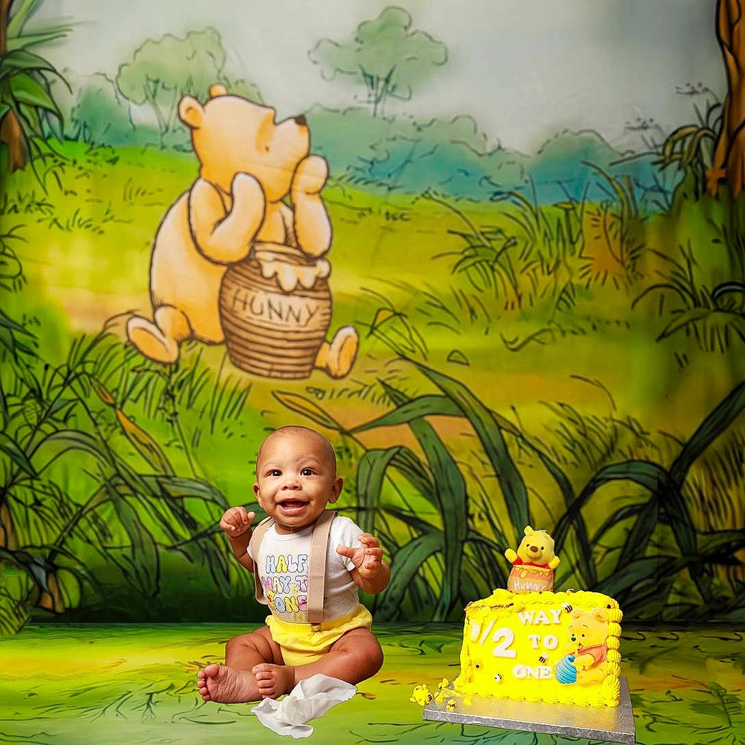 Daquon Jr joined the competition — help win amazing prizes! baby, background, birthday_cake, cake, cartoon, celebration, child, clothing, decor, floor, grass, happy, milestone, onesie, party, sitting, smile, toy, winnie_the_pooh, yellow
