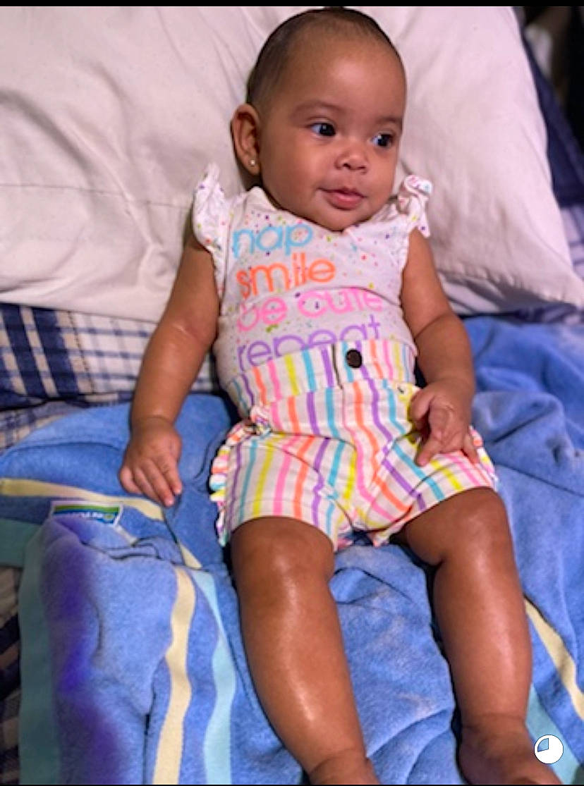 Jazara is registered to the contest to win money with this photo: arm, baby, baby_toddler_clothing, cheek, child, comfort, finger, fun, hand, happy, iris, mouth, pattern, person, purple, skin, sleeve, smile, t_shirt, thigh