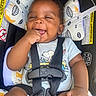 baby, infant, child, smiling, happy, portrait, car_seat, safety_harness, buckled, vehicle, sitting, face, hand, finger, short_sleeves, clothing, patterned_cushion, indoor, closeup, photography
