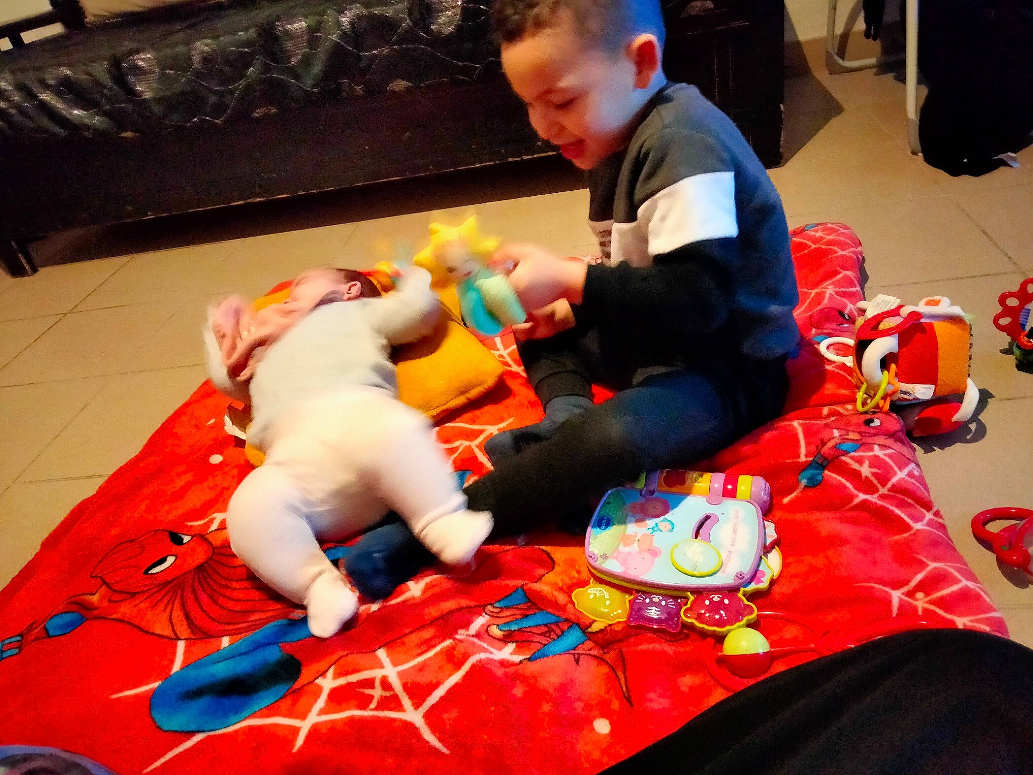 Zakaria participe au concours pour gagner de l'argent avec cette photo : baby_toys, backpack, carmine, child, comfort, event, fictional_character, flooring, fun, games, leisure, person, plastic, play, recreation, room, sitting, t_shirt, toddler, toy