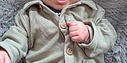 Noha a rejoint le concours — aidez-le/la à gagner de superbes lots ! baby, infant, child, clothing, neutral_colors, jacket, pants, hand, face, eyes, mouth, expression, curious, lying_down, rug, fluffy, texture, indoor, floor, cozy