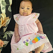 Lily is registered to the contest to win money with this photo: baby, infant, pink_dress, easter_theme, bunny, colorful_eggs, blanket, floral_pattern, lying_down, cute, chubby_cheeks, hand, foot, soft_fabric, indoors, portrait, child, smiling, face, person