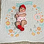 baby, infant, child, milestone_blanket, red_headband, red_booties, pink_onesie, carpet, floor, flower_pattern, months, laying_down, cute, portrait, indoors, adorable, clothing, person, young_child, baby_girl