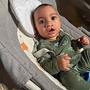 Matthew is registered to the contest to win money with this photo: baby, infant, child, face, eyes, mouth, hand, green_clothing, baby_seat, cushion, fabric, straps, indoor, portrait, young_child, cute, expression, cozy, soft_lighting, comfortable