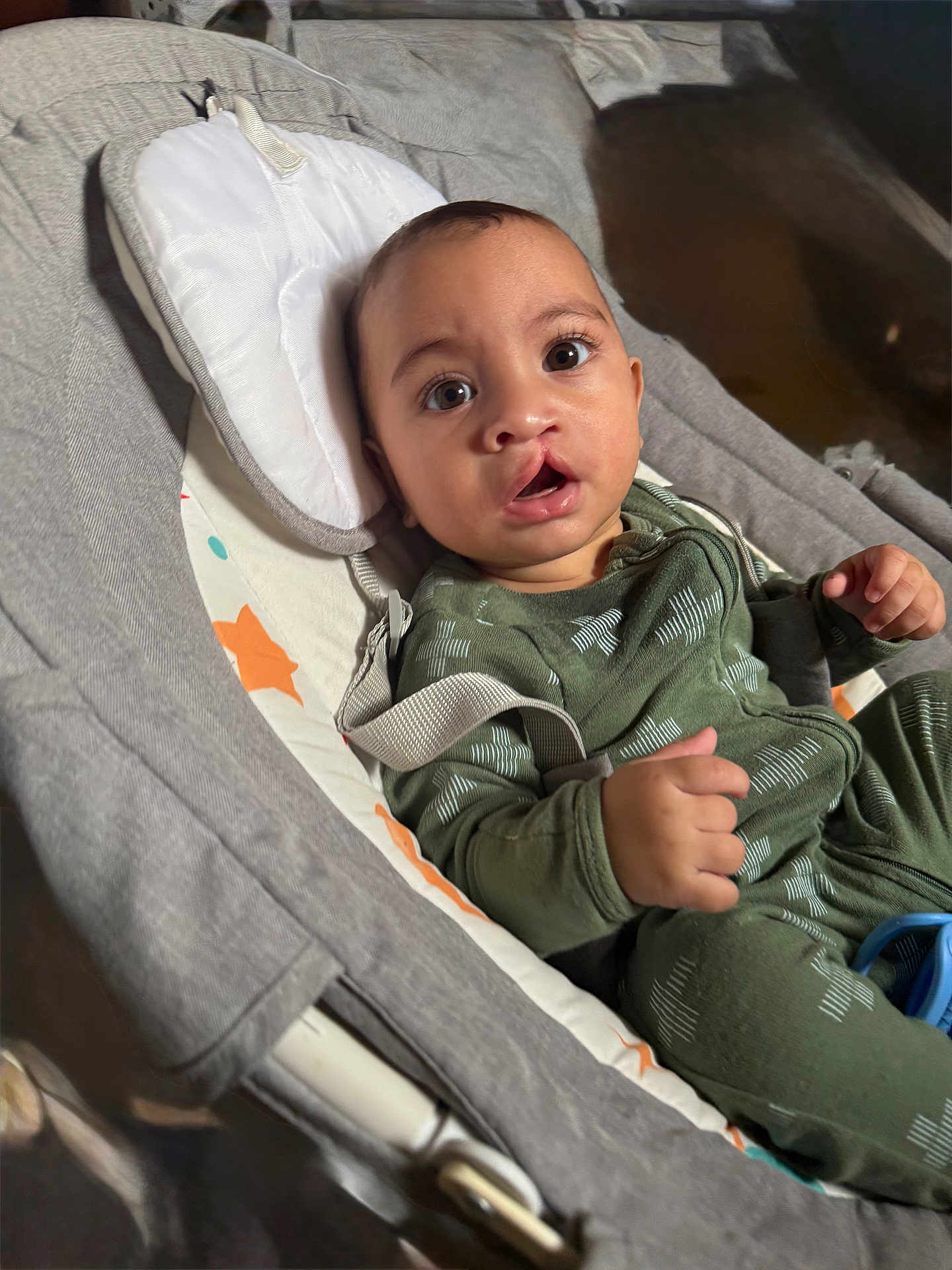 Matthew is registered to the contest to win money with this photo: baby, infant, child, face, eyes, mouth, hand, green_clothing, baby_seat, cushion, fabric, straps, indoor, portrait, young_child, cute, expression, cozy, soft_lighting, comfortable