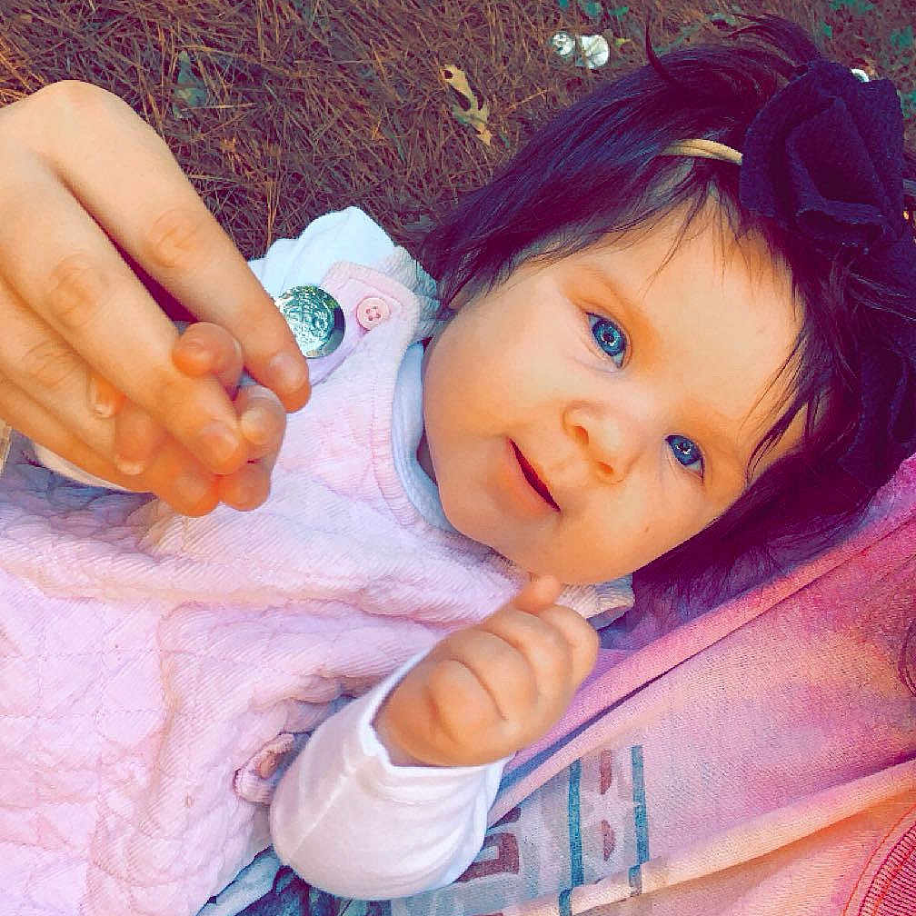 Charleigh Kate is registered to the contest to win money with this photo: baby, blue_eyes, bow, child, closeup, cute, face, grass, hand_holding, happy, headband, infant, leaves, outdoor, person, pink_clothing, portrait, skin, smiling, young_child