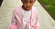 Daqariah joined the competition — help win amazing prizes! child, girl, pink_coat, pink_dress, hair_bows, sidewalk, outdoor, serious_expression, curly_hair, pigtails, green_grass, concrete, steps, fashion, cute, portrait, person, footwear, winter_clothing, young