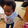 Daqariah is registered to the contest to win money with this photo: toddler, child, indoor, carpet, bracelet, toy, clothing, shirt, jeans, person, footwear, hand, face, hair, basket, bag, furniture, living_room, curious, standing