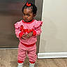 Daqariah is registered to the contest to win money with this photo: toddler, child, striped_clothing, red_bow, silver_boots, standing, wooden_floor, indoor, serious_expression, long_sleeves, pants, person, young_child, hair_bow, red_and_white, casual_wear, footwear, portrait, cute, fashion