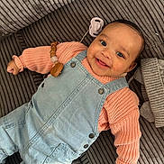 Kaely participe au concours pour gagner de l'argent avec cette photo : baby, child, smile, denim_overalls, knit_sweater, couch, cozy, happy, infant, cute, face, portrait, indoors, clothing, skin, hand, head, comfort, young, lying_down