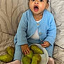 Kaely a rejoint le concours — aidez-le/la à gagner de superbes lots ! baby, infant, child, blue_cardigan, knitwear, pear, fruit, bowl, sofa, cushion, blanket, sitting, open_mouth, surprised, hand, sock, indoor, portrait, cute, home