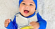 Andy is registered to the contest to win money with this photo: baby, blue_costume, bright_colors, child, costume, cute, expression, fluffy_background, fun, happy, headwear, indoors, infant, lying_down, motion_blur, playful, portrait, smiling, yellow, young_child