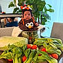 Andy is registered to the contest to win money with this photo: baby, child, clothing, cute, face, food, fresh, funny, greenery, hat, indoor, lettuce, mirror, person, plant, pot, reflection, table, tomatoes, vegetables