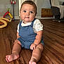 baby, child, infant, sitting, floor, overalls, white_shirt, shark_print, wooden_floor, living_room, toy, chair, blanket, curious, cute, indoors, person, portrait, face, feet