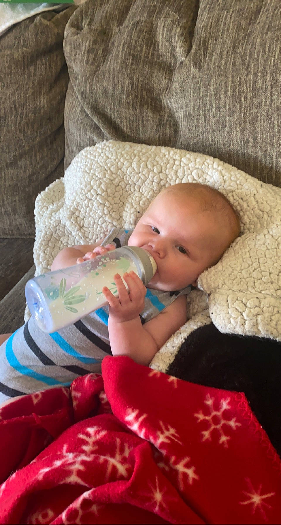 Declan is registered to the contest to win money with this photo: baby, baby_bottle, baby_toddler_clothing, bottle, cheek, child, comfort, drinking, drinkware, finger, head, human_body, nail, person, plastic_bottle, sitting, skin, textile, toddler, water