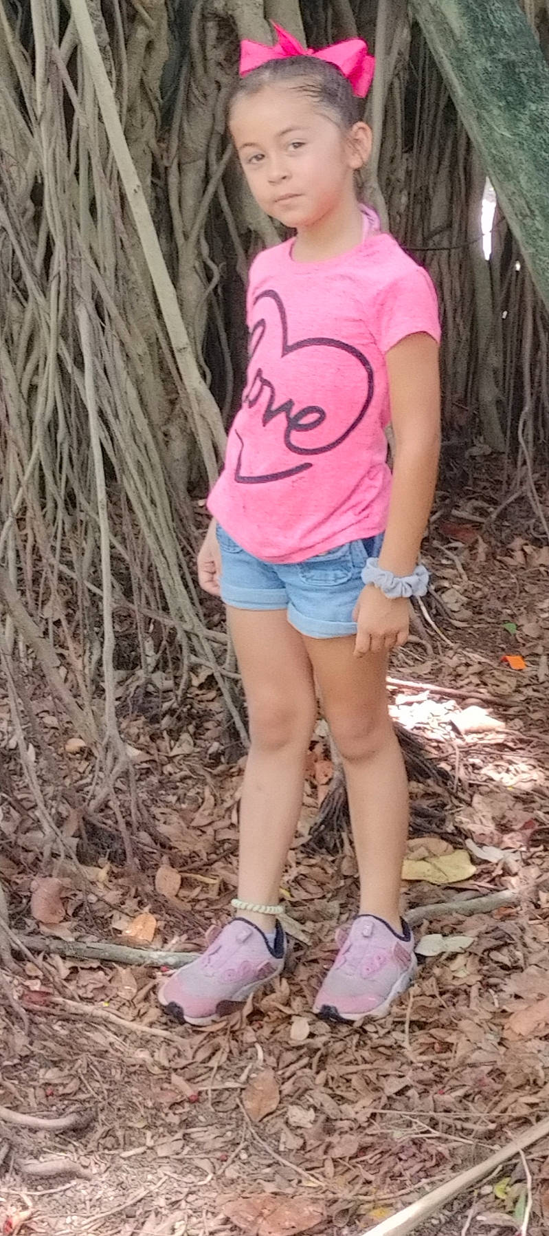 Aliana is registered to the contest to win money with this photo: brown_hair, denim, electric_blue, eyewear, grass, human_leg, joint, knee, leg, long_hair, people_in_nature, person, pink, shoe, shorts, soil, t_shirt, thigh, trunk, waist