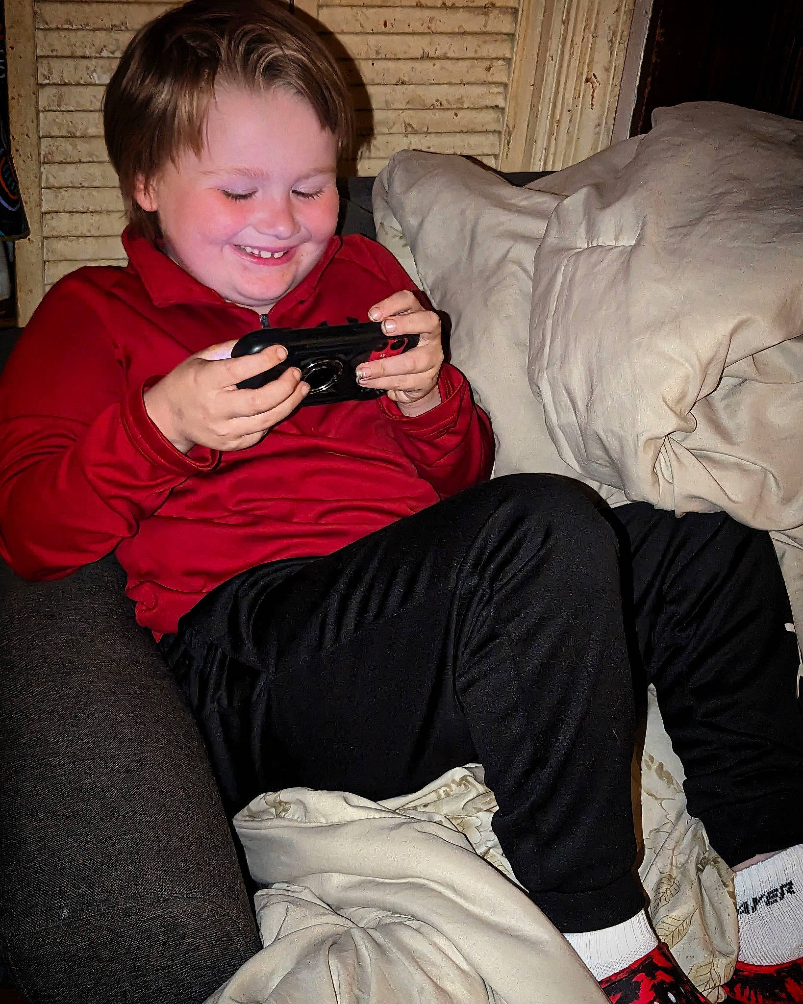 Keegan is registered to the contest to win money with this photo: child, comfort, cool, elbow, event, eye, fun, happy, head, human_leg, joy, knee, lap, leg, mammal, mouth, person, sitting, sleeve, smile