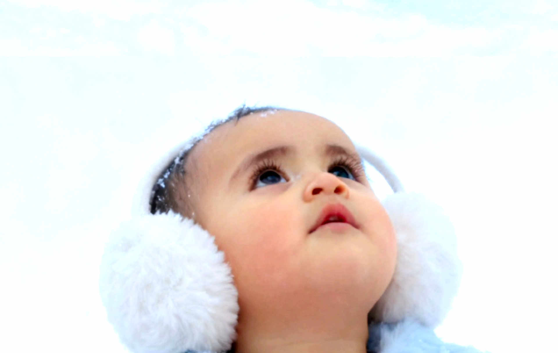 Pearl is registered to the contest to win money with this photo: baby, child, face, earmuffs, winter, snow, cold, portrait, closeup, fluffy, cute, looking_up, headwear, outdoor, skin, eyelashes, winter_clothing, young, innocent, soft