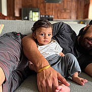 Uday joined the competition — help win amazing prizes! baby, child, toddler, person, adult, hand, foot, couch, sofa, living_room, indoor, clothing, bracelet, wooden_cabinets, kitchen, beard, casual, comfort, family, protective
