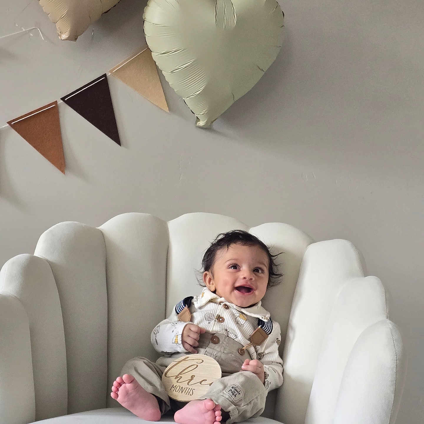 Uday joined the competition — help win amazing prizes! baby, balloon, banner, celebration, chair, clothing, cute, decor, feet, happy, heart_balloon, indoors, infant, overalls, person, portrait, smiling, three_months, toddler, white_chair