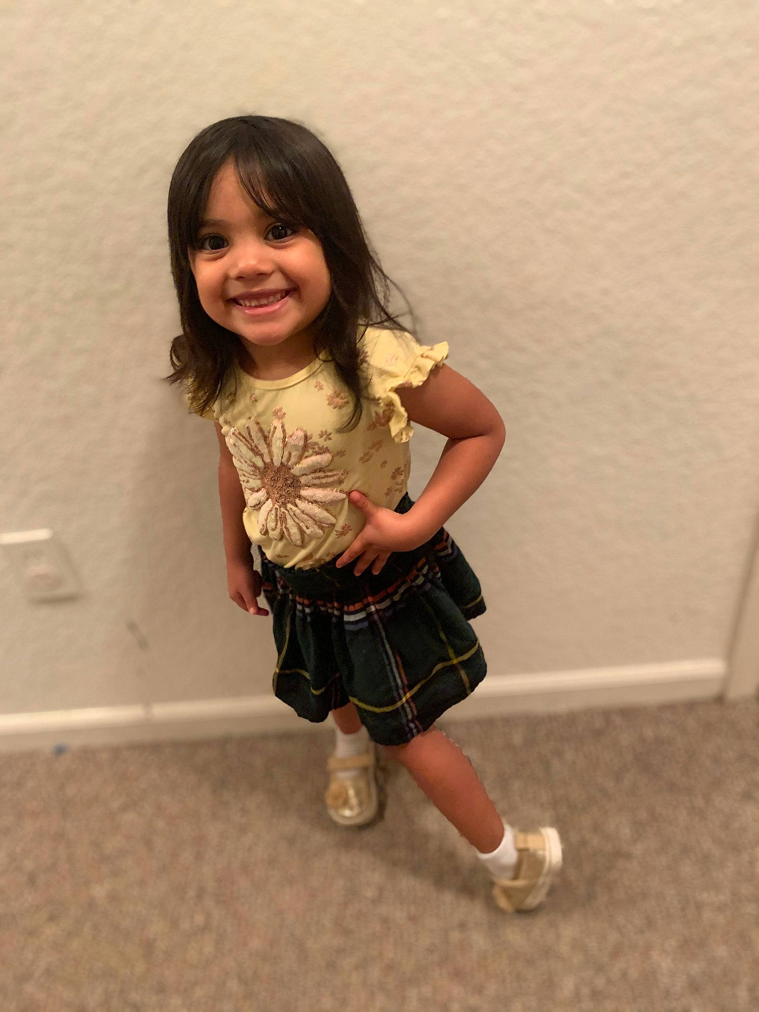 Kamila is registered to the contest to win money with this photo: baby_toddler_clothing, clothing, facial_expression, flooring, fun, hair, happy, human_leg, joy, knee, long_hair, person, plaid, skin, sleeve, smile, sock, standing, tartan, thigh