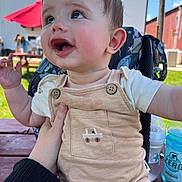 Ashton joined the competition — help win amazing prizes! baby, bottle, building, cheeks, child, drink, face, gatorade, grass, hand, happy, infant, outdoor, person, picnic_table, romper, seat, smiling, sunny, umbrella