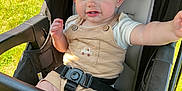 Ashton joined the competition — help win amazing prizes! baby, baby_clothes, cheeks, child, clothing, cute, expression, face, grass, hand, head, infant, outdoor, person, seatbelt, sitting, smiling, stroller, sunlight, toy