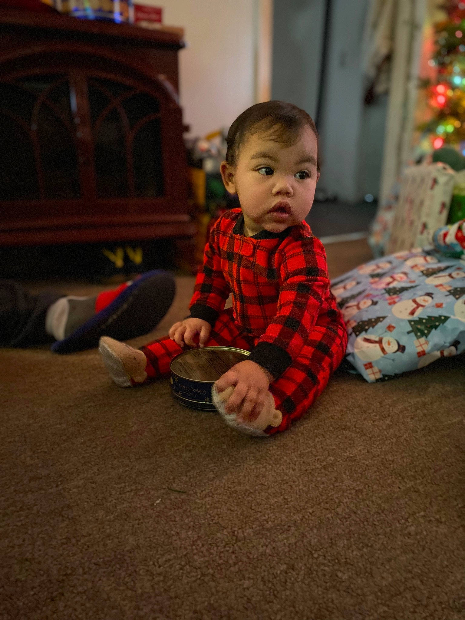 Alora is registered to the contest to win money with this photo: baby, baby_toddler_clothing, carmine, child, christmas, comfort, event, floor, flooring, fun, hardwood, holiday, living_room, person, room, sitting, sleeve, standing, surprise, toddler