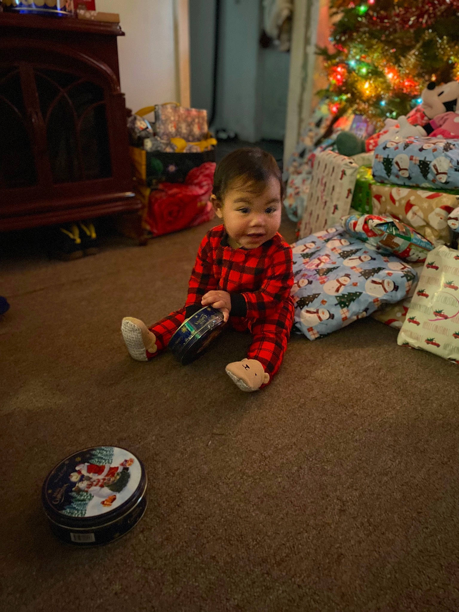 Alora is registered to the contest to win money with this photo: baby, baby_toddler_clothing, child, christmas, christmas_ornament, christmas_tree, event, floor, flooring, fun, happy, holiday, lap, living_room, person, play, room, sitting, toddler, toy