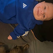 Emilio a rejoint le concours — aidez-le/la à gagner de superbes lots ! baby, blue_hoodie, smile, lying_down, bed, cat, tabby_cat, pet, cozy, indoor, person, child, cute, comfortable, furry, animal, friendship, relaxing, soft, happy